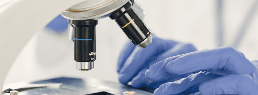 Person in front of a microscope in a laboratory performing controls with IQC Ellistat software